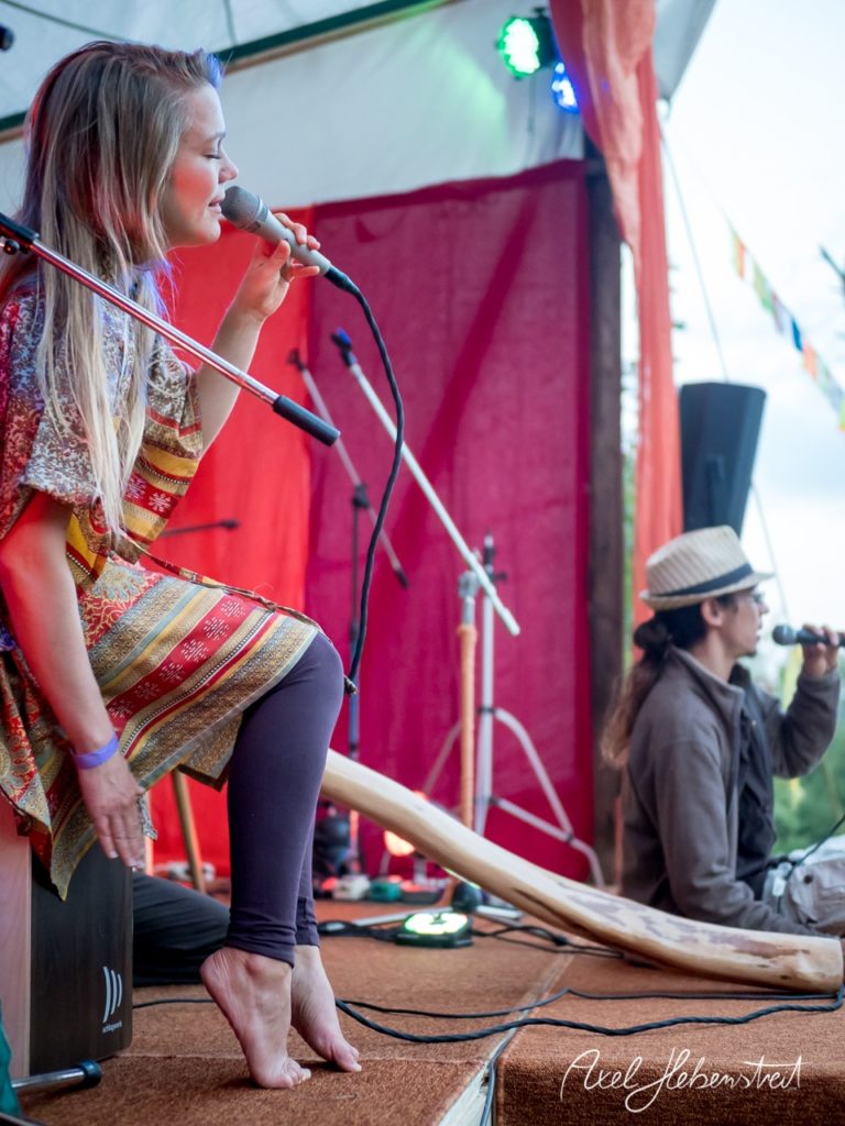 Eine Sängerin mit Mikrofon und ein Musiker auf der Bühne schaffen eine festliche Atmosphäre im Freien. – © Axel Hebenstreit