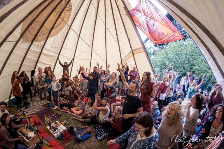 Eine lebendige Versammlung von Menschen in einem Tipi, die gemeinsam Musiziert und Freude ausdrückt. – © Axel Hebenstreit