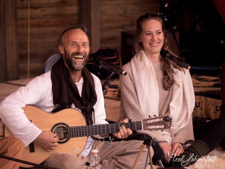 Ein strahlendes Musikerpaar präsentiert ein Lied in entspannter Festivalatmosphäre. – © Axel Hebenstreit