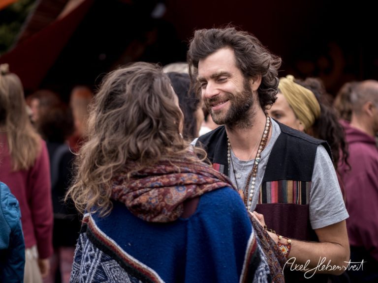 Ein lächelndes Paar unterhält sich in einer lebhaften Festivalatmosphäre. – © Axel Hebenstreit