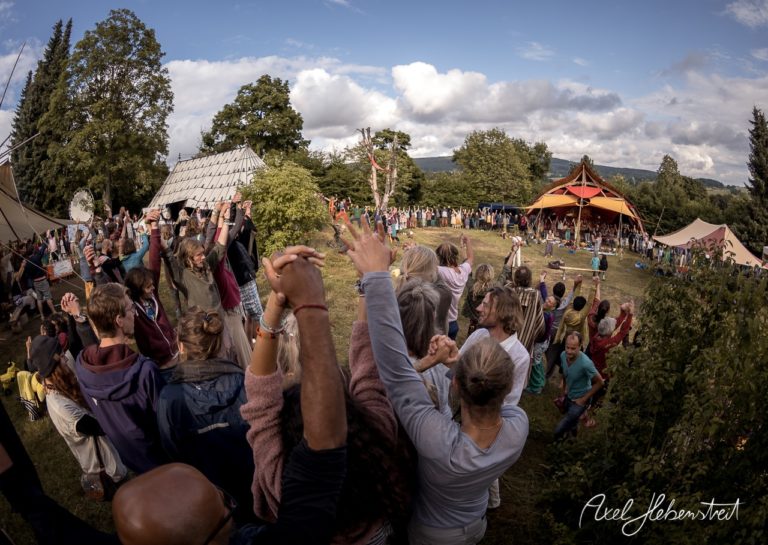 Eine fröhliche Gemeinschaft tanzt und feiert im Freien bei einem Festival in Bayern. – © Axel Hebenstreit
