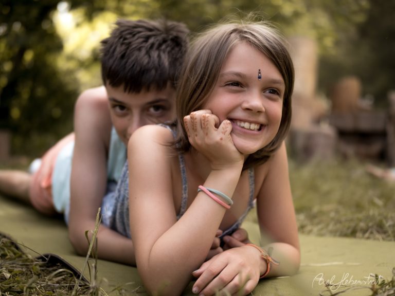 Zwei Kinder spielen fröhlich im Schlamm und Wasser in der Natur, lachen und genießen unbeschwerte Momente – © Axel Hebenstreit