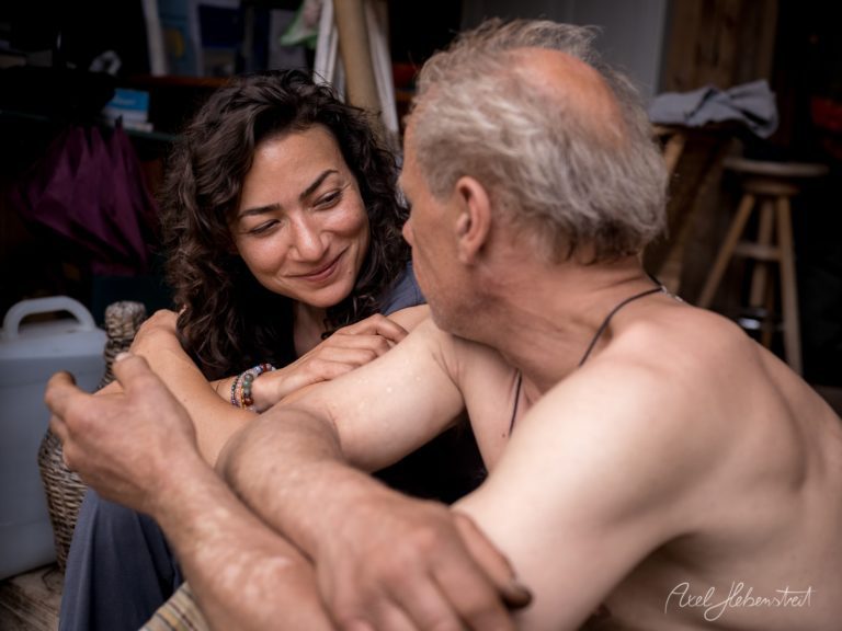 Zwei Menschen teilen einen intimen Moment beim Tanzen in einem gemütlichen Innenraum mit warmer Atmosphäre – © Axel Hebenstreit