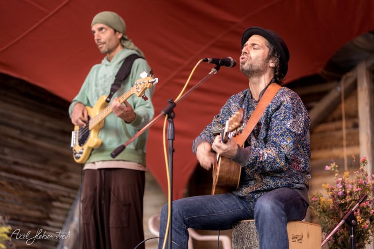 Zwei Musiker auf einer Bühne spielen akustische Musik in einer entspannten Festivalatmosphäre – © Axel Hebenstreit