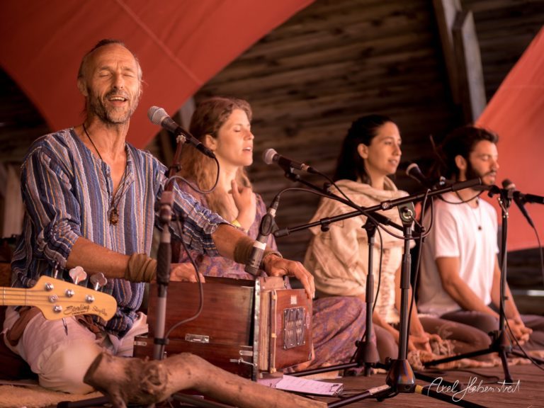 Musiker und Sänger bei einer Yoga-Session auf einem Festival, harmonische Atmosphäre inmitten der Natur – © Axel Hebenstreit