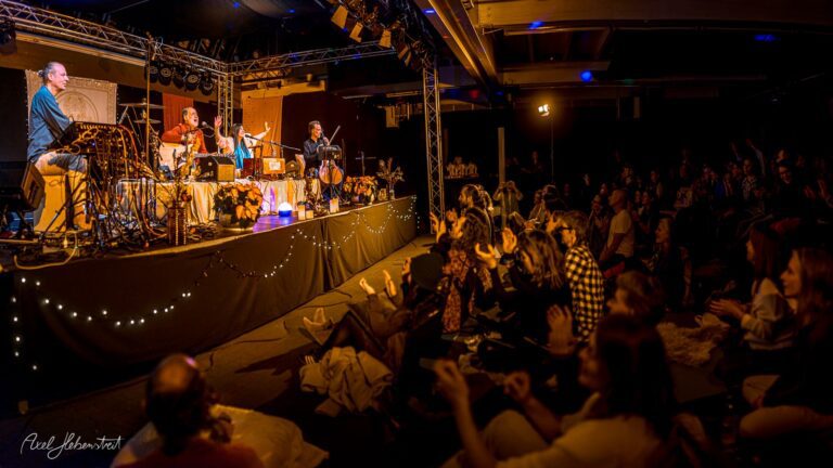 Eine Band spielt vor einem begeisterten Publikum in einer stimmungsvollen Konzertlocation – © Axel Hebenstreit