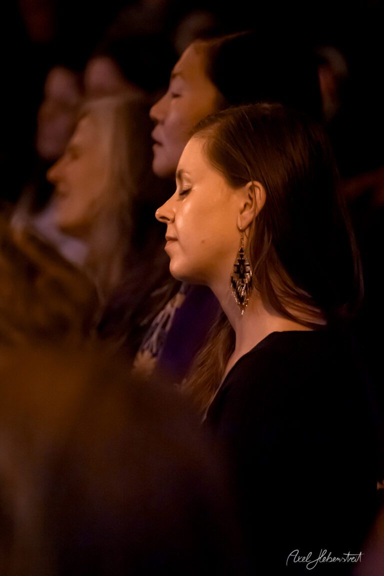 Eine Frau mit geschlossenen Augen genießt die Musik in einem Konzertsaal – © Axel Hebenstreit