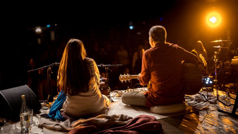 Zwei Musiker sitzen auf der Bühne und spielen in einer entspannten Festivalatmosphäre – © Axel Hebenstreit