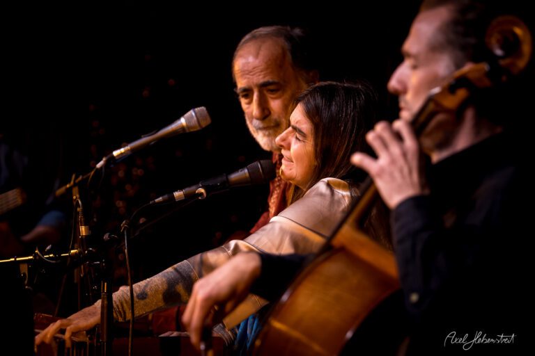 Drei Musiker inmitten einer Aufführung, konzentriert und emotional, im warmen Licht einer Bühnenatmosphäre – © Axel Hebenstreit