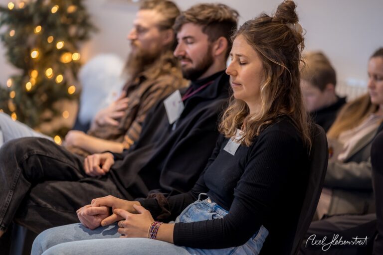 Teilnehmer einer Meditationssession sitzen ruhig in einer Atmosphäre von Achtsamkeit und Entspannung. – © Axel Hebenstreit