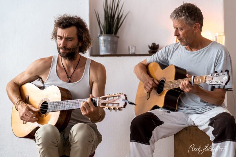 Zwei Musiker spielen akustische Gitarre in einem hellen, minimalistischen Raum – © Axel Hebenstreit