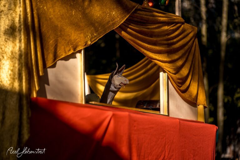 Ein Handpuppen-Theater mit einem neugierigen Esel auf einer bunten Bühne im Freien – © Axel Hebenstreit