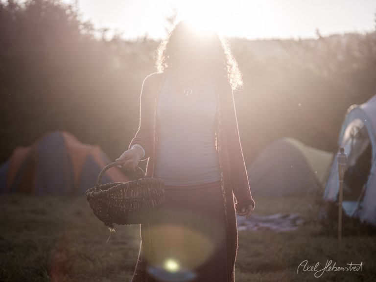 Frau mit Korb in goldener Gegenlicht-Atmosphäre auf ländlichem Gelände bei Sonnenaufgang – © Axel Hebenstreit