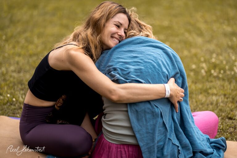 Zwei Frauen umarmen sich herzlich im Freien, umgeben von einer entspannten, harmonischen Atmosphäre. – © Axel Hebenstreit