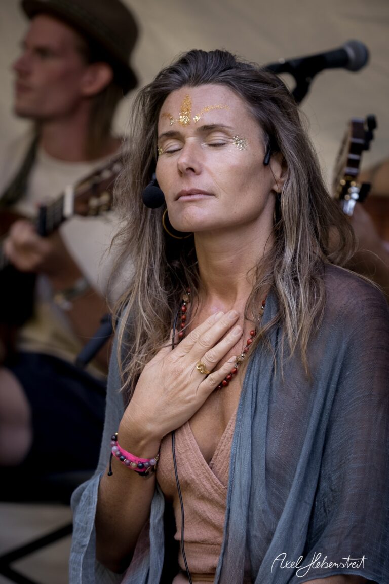 Meditierende Frau mit geschlossenen Augen und traditionellem Makeup, umgeben von musikalischer Atmosphäre auf einem Festival – © Axel Hebenstreit