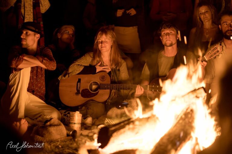 Lagerfeuer-Atmosphäre mit Menschen, die Musik spielen und meditativ lauschen – © Axel Hebenstreit