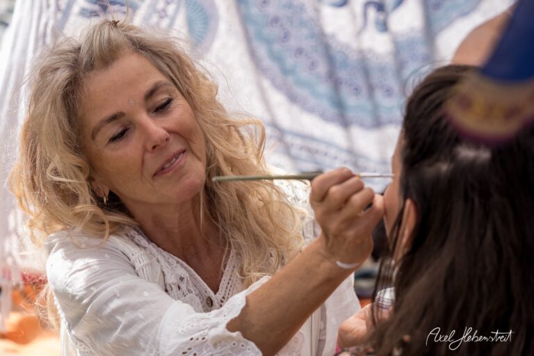 Frau beim Auftragen von Make-up in einer entspannten Festivalatmosphäre – © Axel Hebenstreit
