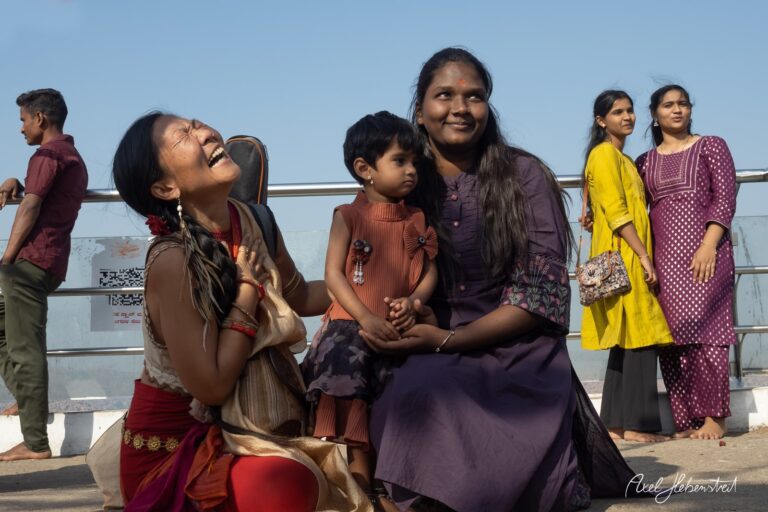 Freudige Frauen mit Kind lächeln in der Sonne, im Hintergrund Menschen und eine entspannte Atmosphäre – © Axel Hebenstreit
