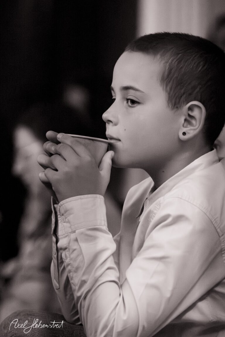Nachdenklicher Junge mit Becher, der in ruhiger Atmosphäre einen Moment der Stille genießt – © Axel Hebenstreit