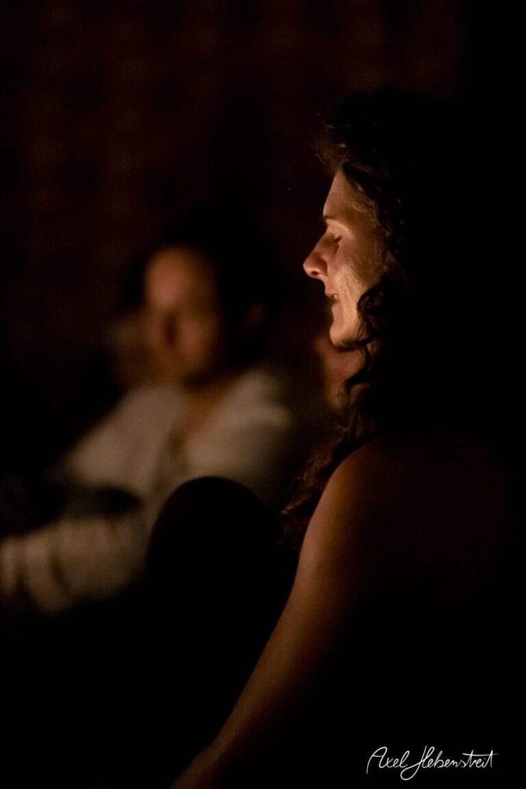 Eine nachdenkliche Frau im Kerzenschein, umgeben von einer ruhigen, meditativen Atmosphäre. – © Axel Hebenstreit