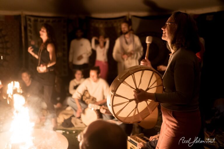 Feiernde Menschen in einem Zelt um ein Feuer, die Musik machen und die spirituelle Atmosphäre genießen – © Axel Hebenstreit
