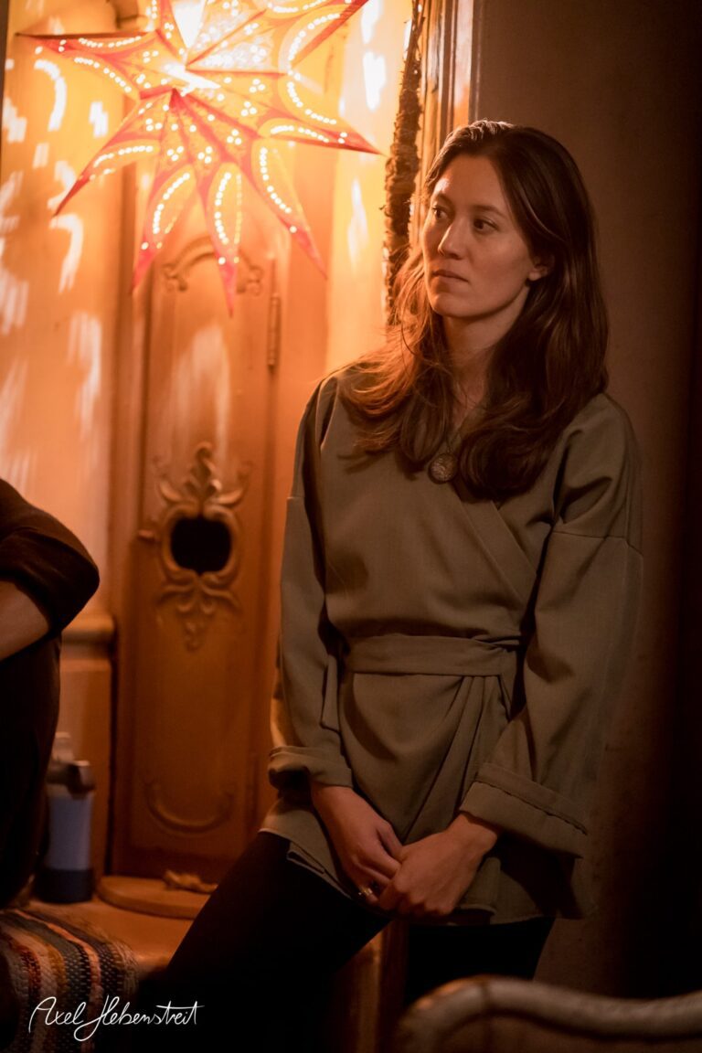 Eine nachdenkliche Frau in einem gemütlichen Raum, erleuchtet von einer dekorativen Sternenlampe. – © Axel Hebenstreit