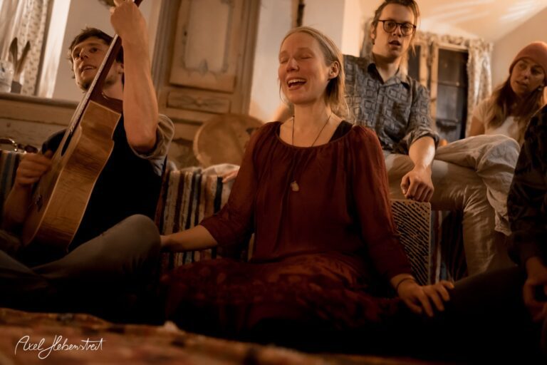 Intime Musizierstunde mit singenden Teilnehmern in gemütlicher, gedämpfter Atmosphäre – © Axel Hebenstreit