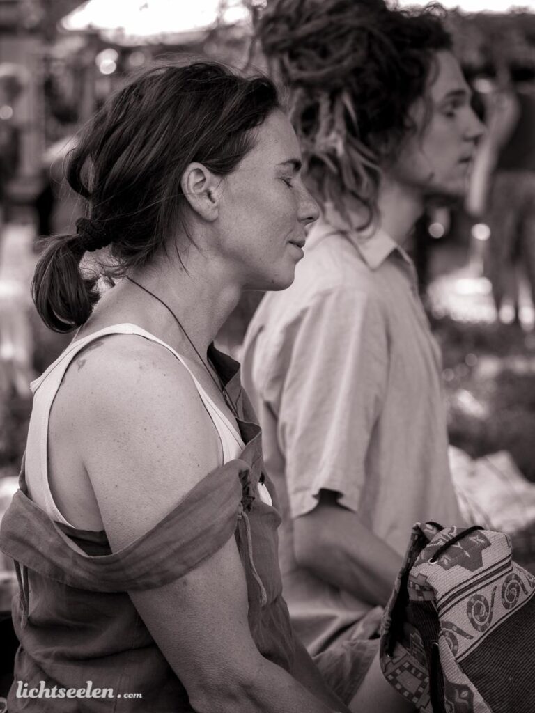 Zwei entspannte Personen im Profil, sitzend auf einem Markt, vermitteln eine ruhige, meditative Stimmung.