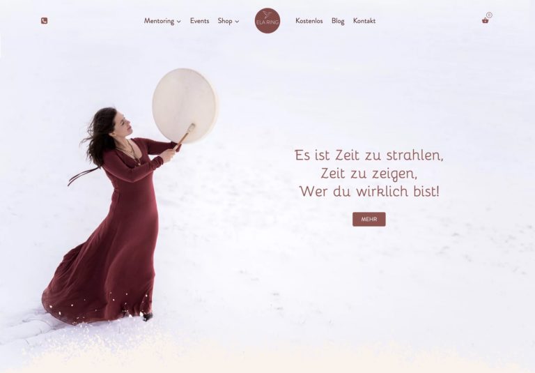 Frau in rotem Kleid spielt auf Trommel im Schnee und strahlt Lebensfreude aus – © Axel Hebenstreit