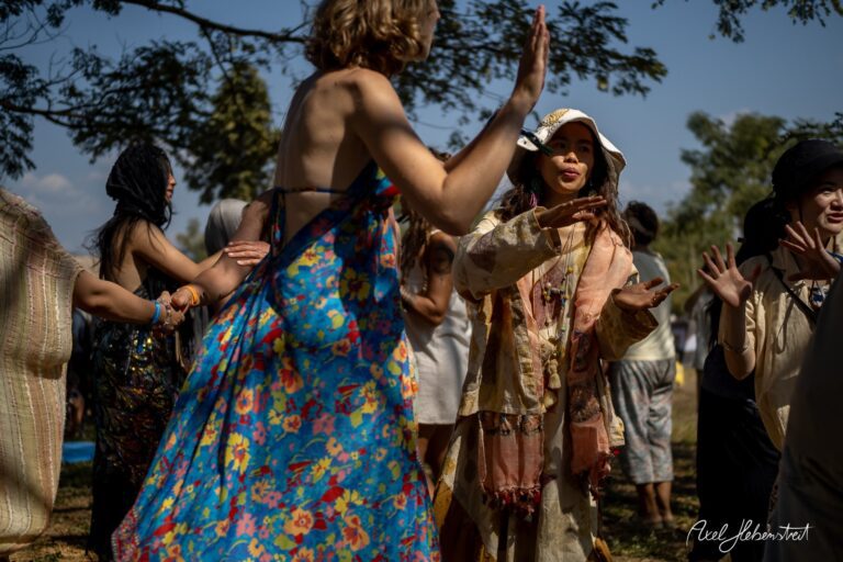 Gemütliche Festivalkultur mit tanzenden Menschen in bunten Outfits unter einem blauen Himmel – © Axel Hebenstreit