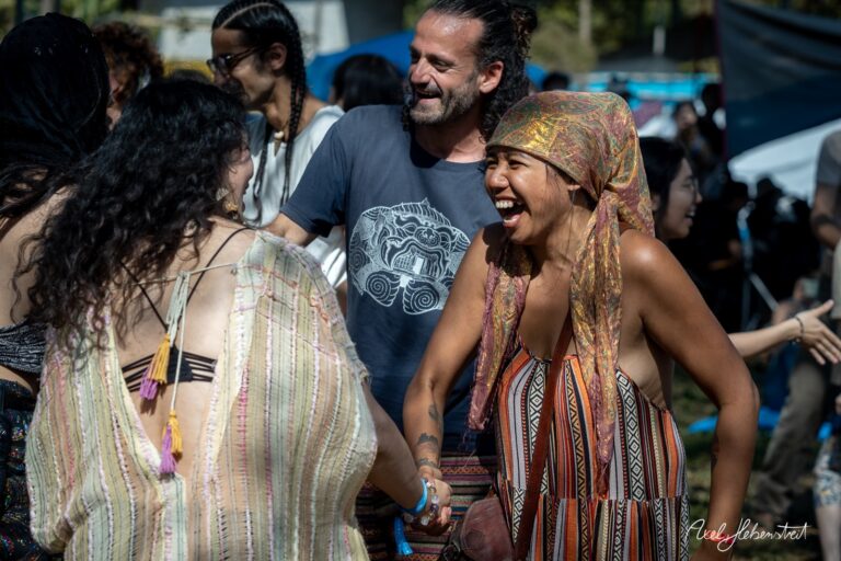 Lachende Menschen tanzen und feiern auf einem Festival in der Natur. – © Axel Hebenstreit