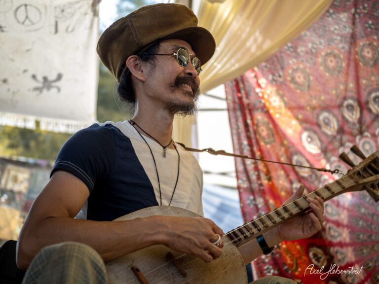 Musiker im Hut spielt mit Leidenschaft ein traditionelles Instrument auf einem Festival – © Axel Hebenstreit