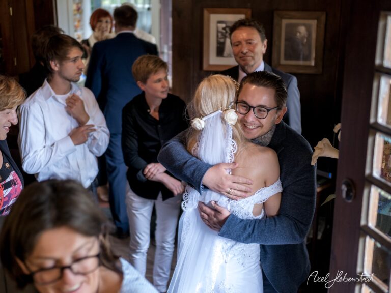 Herzlicher Umarmungsmoment zwischen Braut und Gast in festlicher Atmosphäre – © Axel Hebenstreit