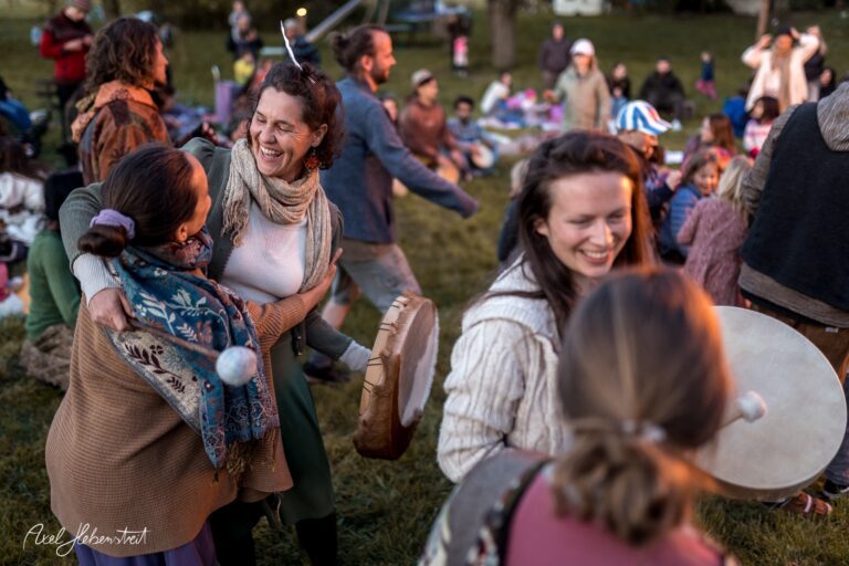 Menschen tanzen und feiern fröhlich im Freien bei einem Festival, umgeben von anderen Teilnehmern – © Axel Hebenstreit