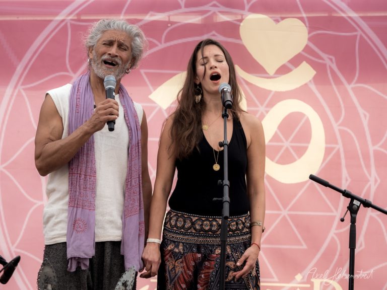 Zwei Sänger performen gemeinsam auf einer Bühne mit rosa Hintergrund und Herzmotiven – © Axel Hebenstreit