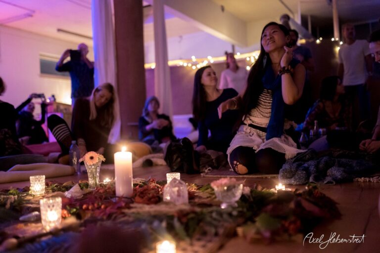 Eine entspannte Atmosphäre bei einem Yoga-Event, umgeben von Kerzenlicht und einer Gruppe von Menschen. – © Axel Hebenstreit