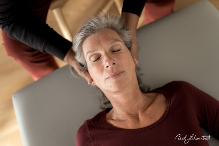 Eine Frau erhält eine entspannende Massage, während sie ruhig auf einer Liege liegt. – © Axel Hebenstreit