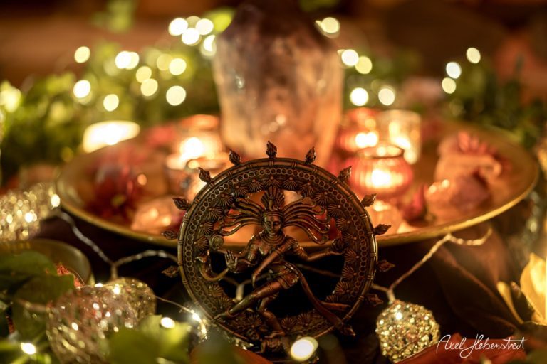 Ein kunstvoll dekorierter Altar mit einer Statue von Shiva, Kerzen und funkelnden Lichtern schafft eine spirituelle Atmosphäre – © Axel Hebenstreit