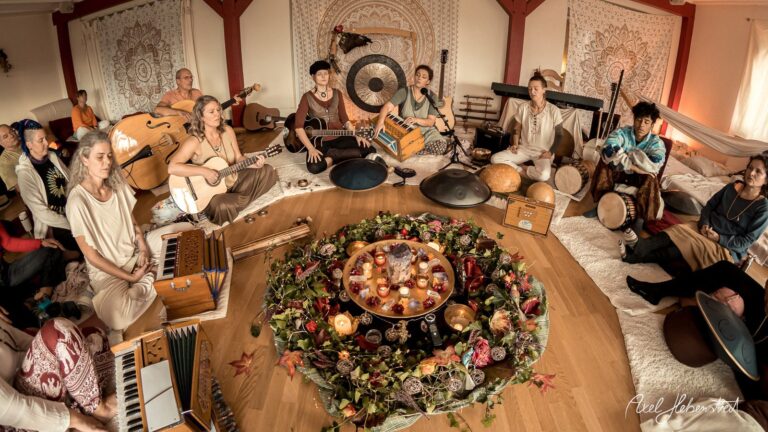 Eine Gruppe von Musikern spielt gemeinsam in einem harmonischen Raum, umgeben von Instrumenten und dekorativen Elementen – © Axel Hebenstreit