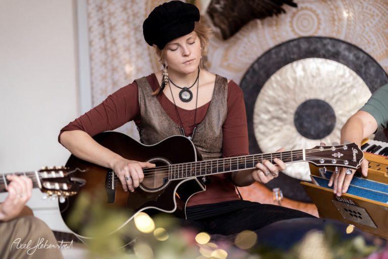 Musikerin mit Gitarre in entspannter Atmosphäre während eines Konzerts – © Axel Hebenstreit