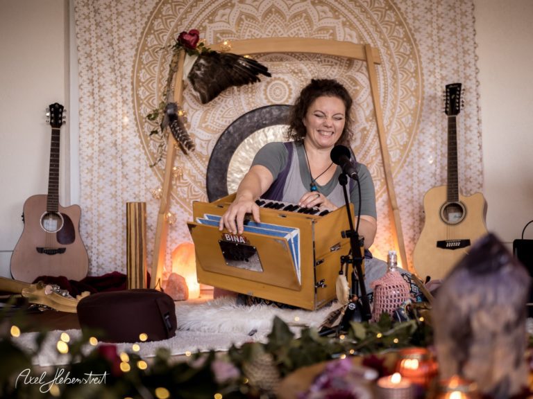 Musikerin spielt mit Freude ein Harmonium in einer harmonischen, spirituellen Umgebung – © Axel Hebenstreit