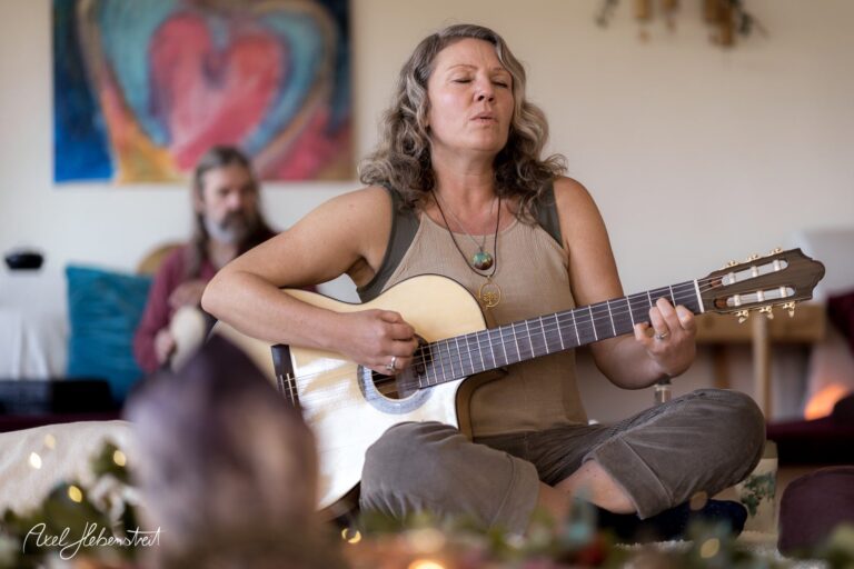 Eine Frau spielt konzentriert Gitarre in einer entspannten Atmosphäre mit harmonischer Stimmung – © Axel Hebenstreit