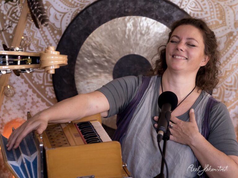 Frau spielt mit Freude auf einem Harmonium und genießt den Moment in einem kreativen, harmonischen Umfeld – © Axel Hebenstreit