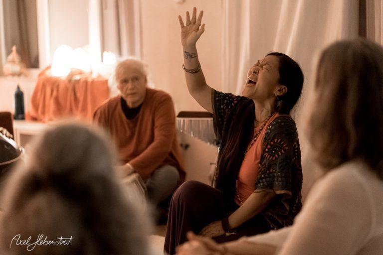 Eine leidenschaftliche Sängerin in einem meditativen Moment während einer Gruppenveranstaltung – © Axel Hebenstreit