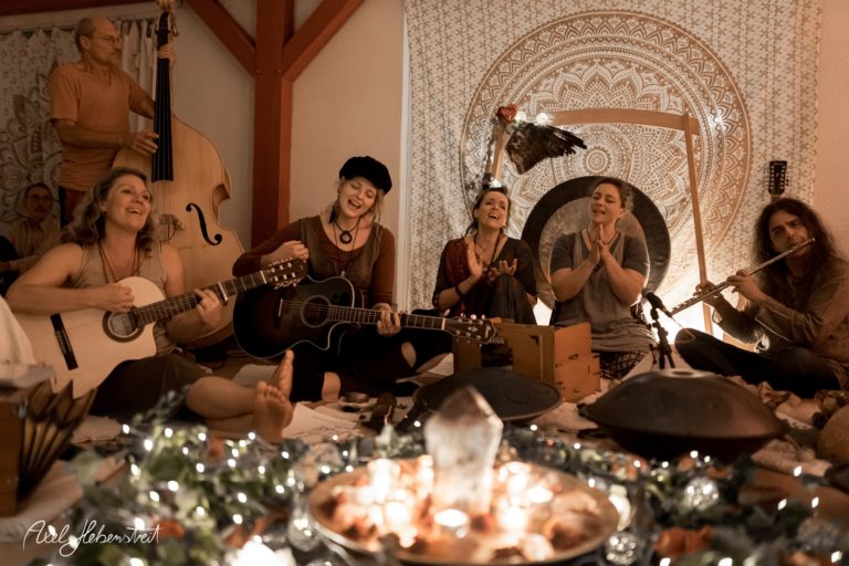 Eine Gruppe von Musikern spielt harmonisch, umgeben von Kerzenlicht und einer entspannten Atmosphäre – © Axel Hebenstreit.