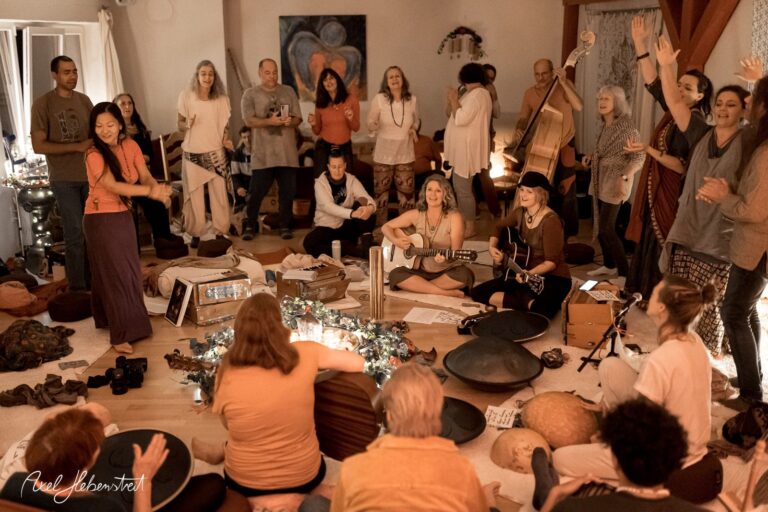 Gemeinschaftliches Musizieren in einem festlichen Raum, umgeben von Lichtern und fröhlichen Menschen – © Axel Hebenstreit