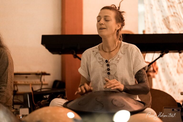Eine Musikerin spielt entspannt auf einem Handpan, umgeben von einer kreativen und harmonischen Atmosphäre. – © Axel Hebenstreit