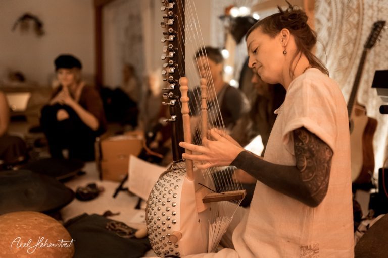 Musikerin spielt eine traditionelle Saiteninstrument in einer entspannten Atmosphäre bei einem Event – © Axel Hebenstreit