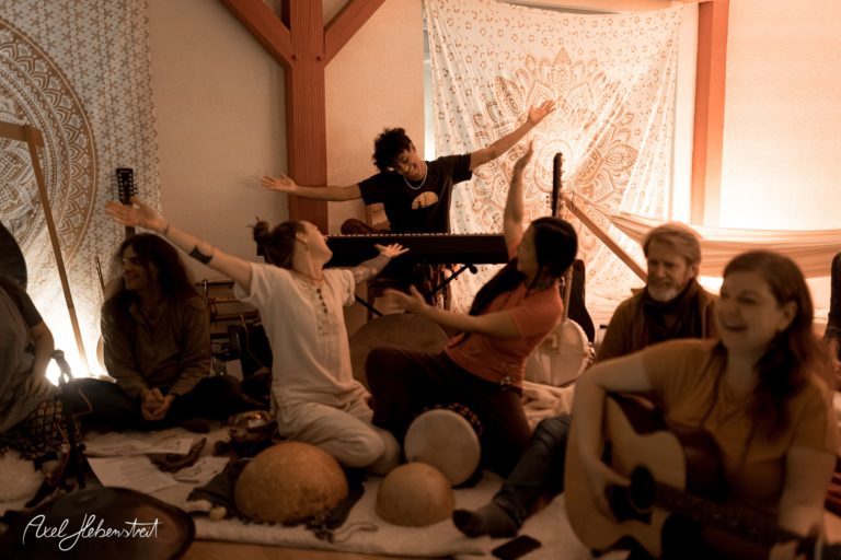 Leidenschaftliche Musiker und Tänzerinnen in einer entspannten, spirituellen Atmosphäre während eines kreativen Events – © Axel Hebenstreit
