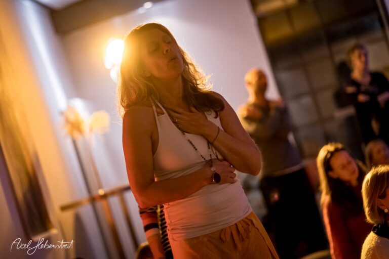 Frau in meditativer Pose mit hand auf dem Herzen in einem beruhigenden Yoga-Setting – © Axel Hebenstreit